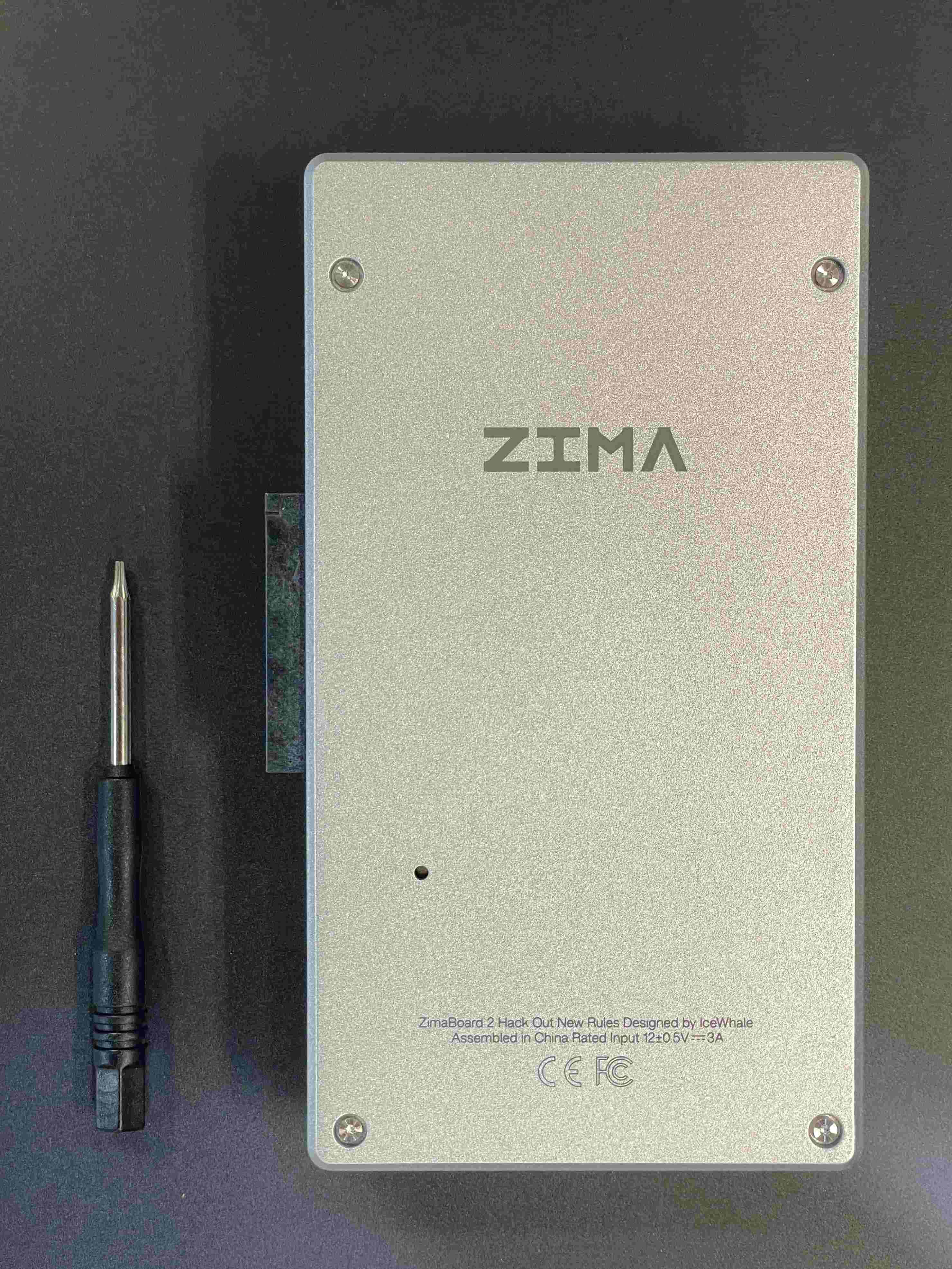 ZimaBoard 2 rear cover removal with T5 Torx screwdriver—loosen four screws to open the back panel (fan installation step).