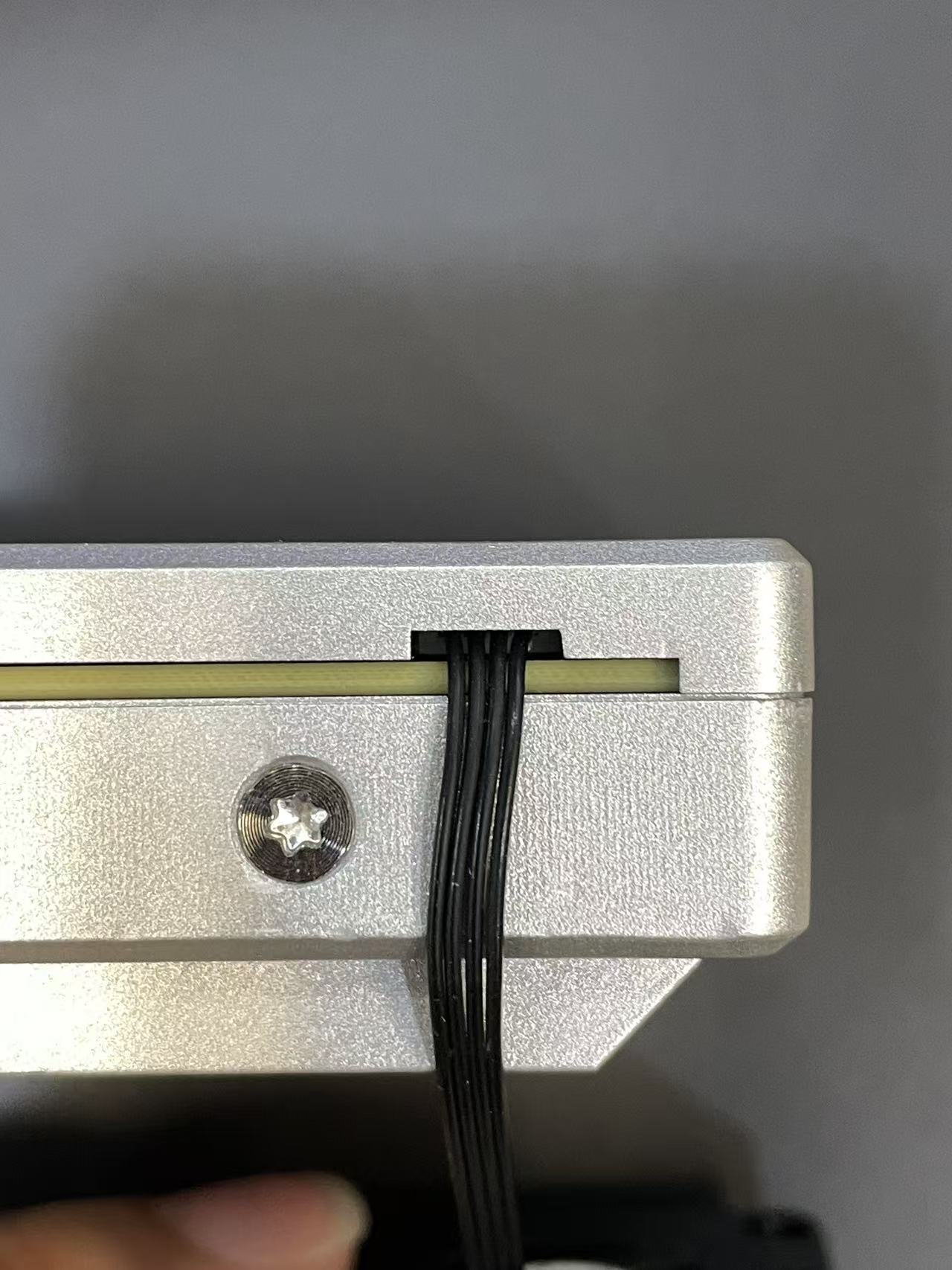 ZimaBoard 2 side notch cable routing—PWM fan cable exiting through the chassis notch to prevent pinching; refit rear cover and tighten screws (fan installation).